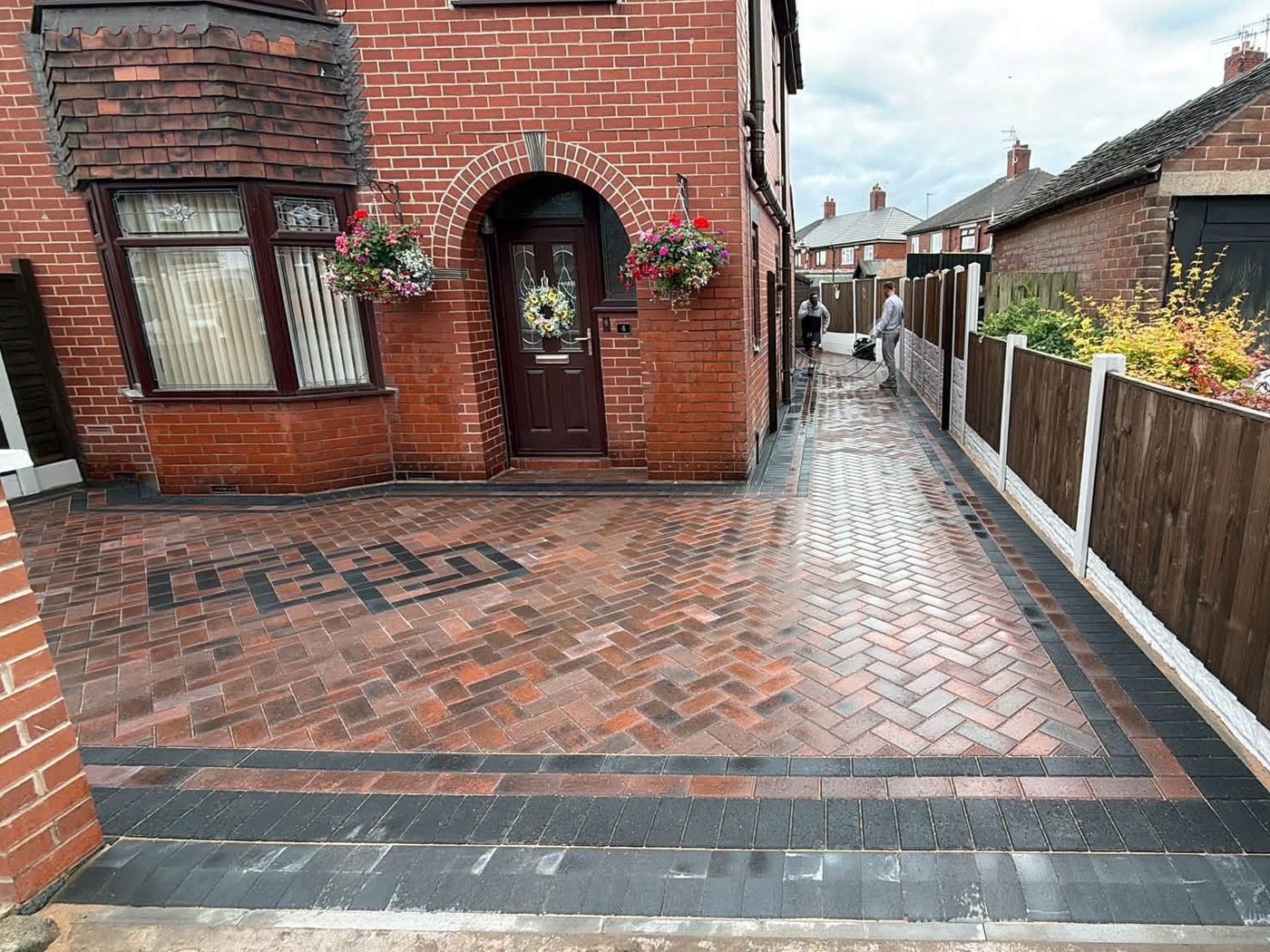 The same driveway laid in red herringbone block paving with a charcoal border