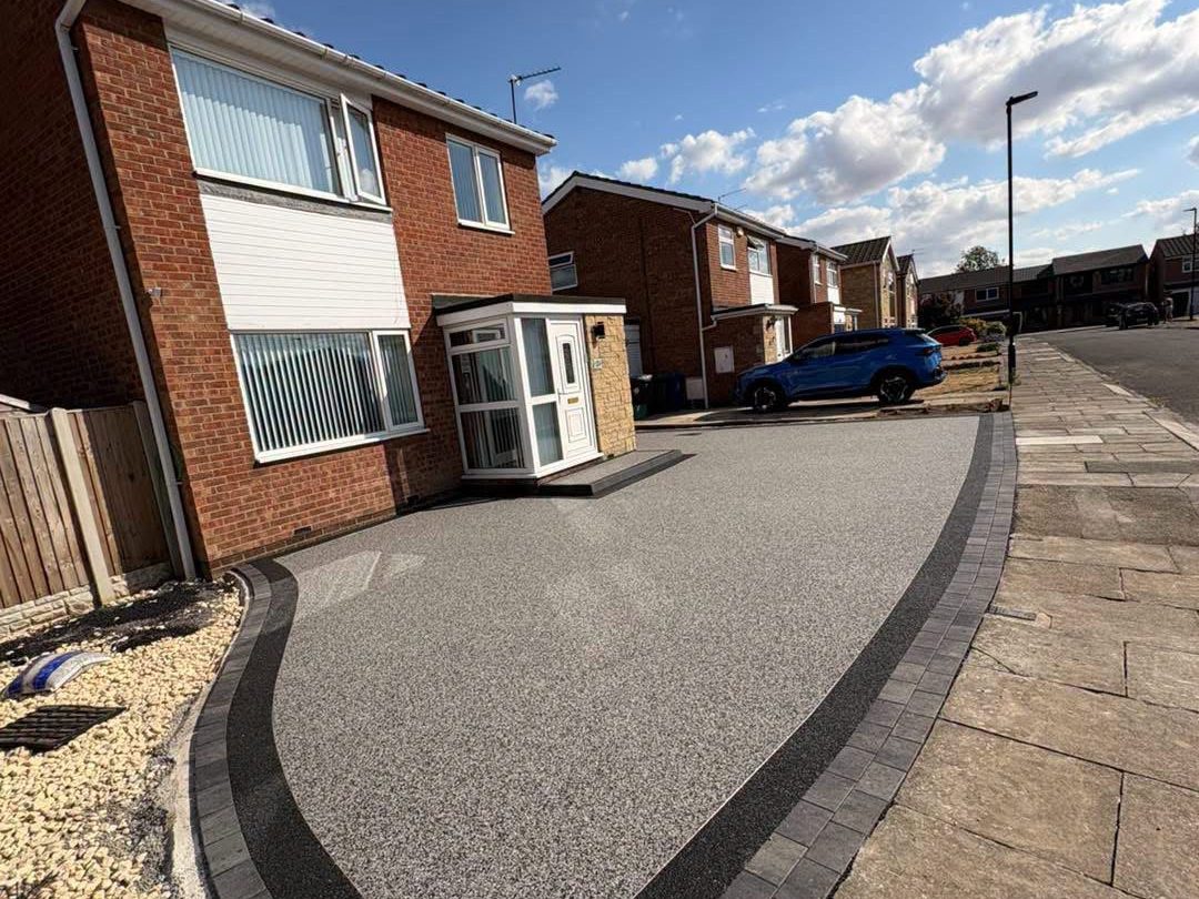 The same frontage as a grey resin bound driveway with a charcoal border