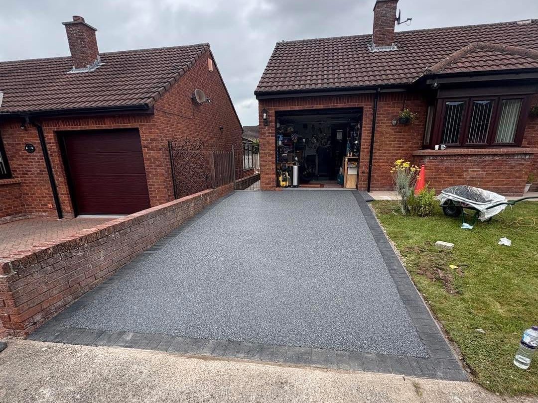 The same bungalow driveway finished in grey resin bound stone with a charcoal block edge