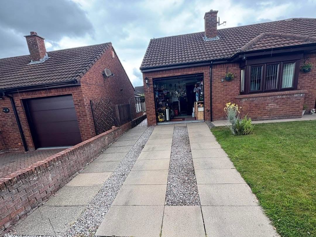 Old concrete slabs and gravel strips on a bungalow driveway before the resin went down