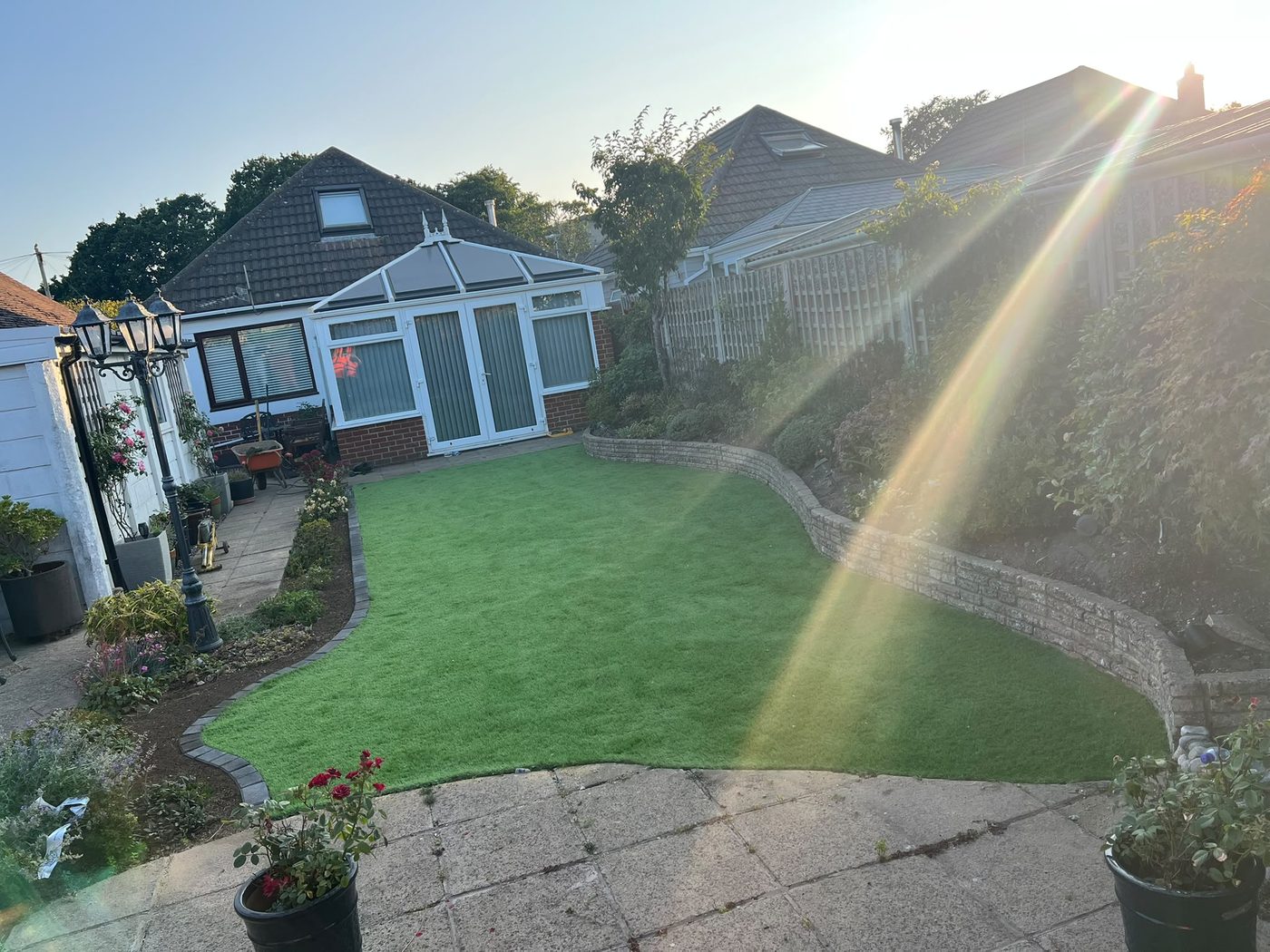 The same garden with an artificial lawn and a curved block edge