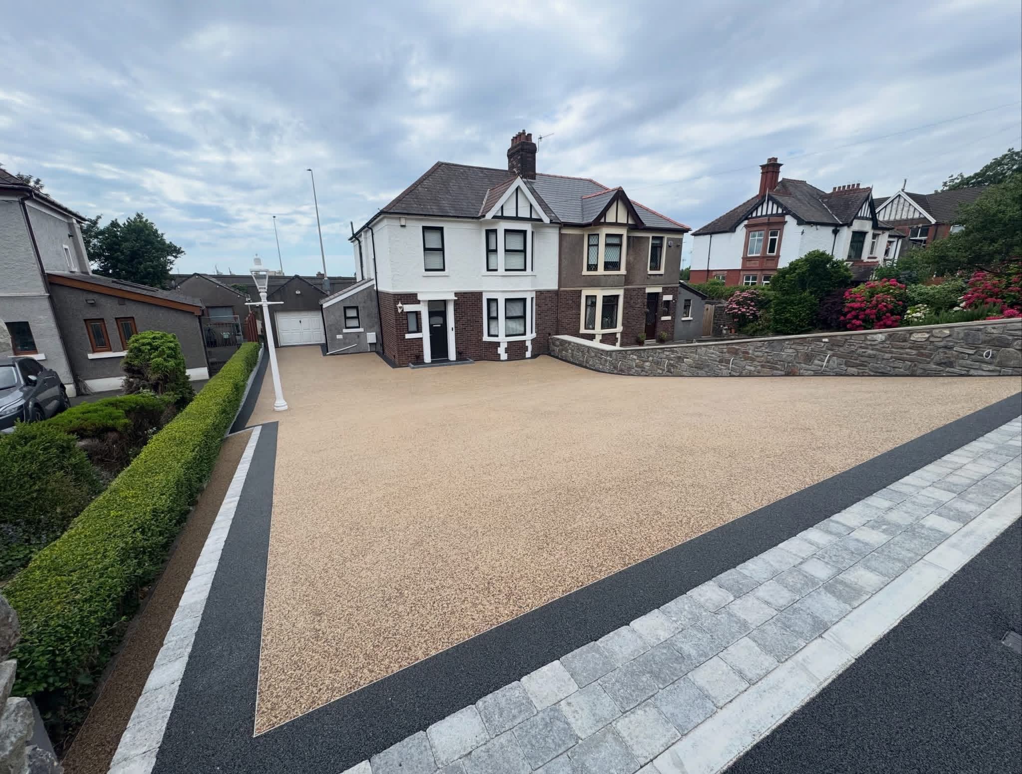 Buff resin bound driveway with charcoal and granite borders laid by Rightway Roofing and Driveways