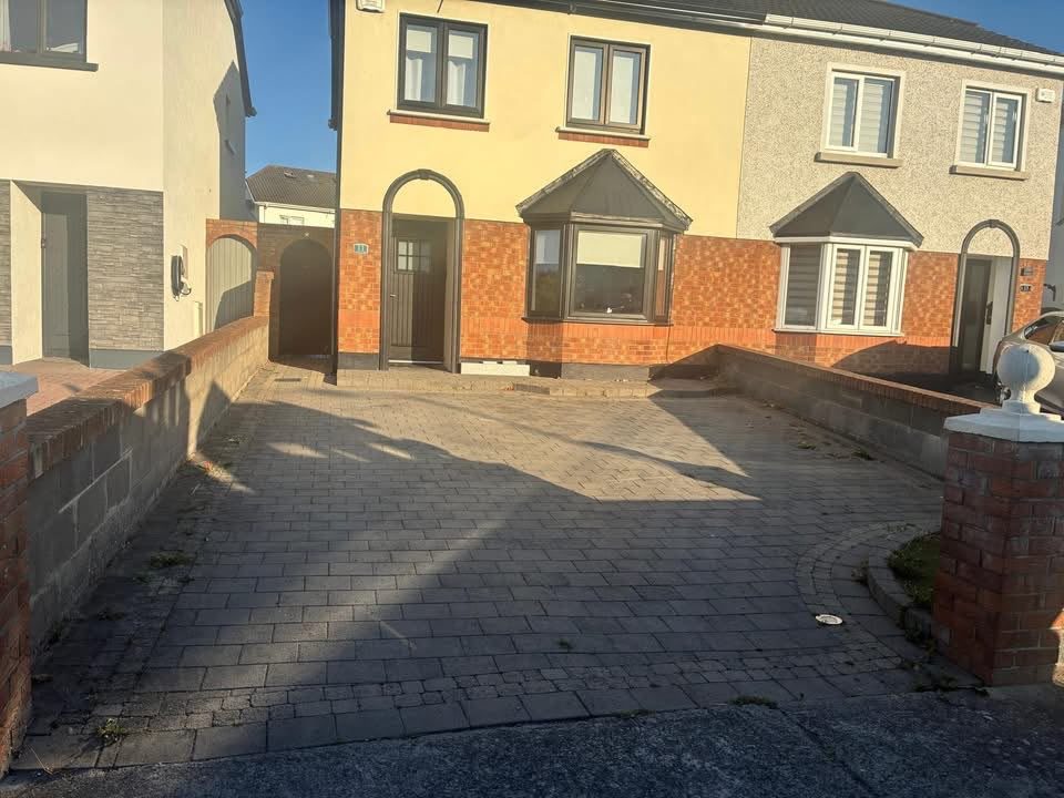 Charcoal block paved driveway between brick walls on a semi detached house